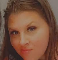 Woman with brown hair and eyes, looking towards the camera, soft expression.