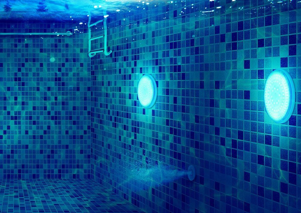 A Swimming Pool With Blue Tiles and Lights Underwater — Taree Pool Supplies in Harrington, NSW