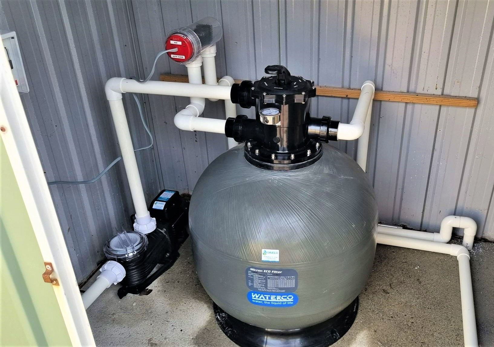 A Swimming Pool Filter is Sitting in a Shed Next to a Pump — Taree Pool Supplies in Taree, NSW