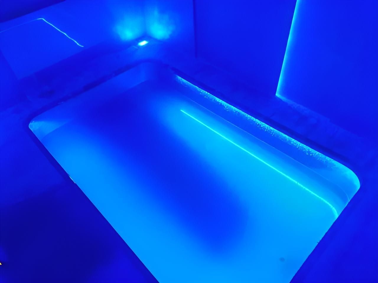 A Pool is Lit Up With Blue Lights in a Dark Room — Taree Pool Supplies in Taree, NSW