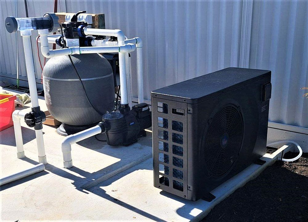 A Large Black Box is Sitting Next to a Pool Filter — Taree Pool Supplies in Taree, NSW