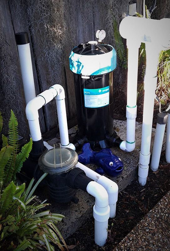 A Pool Filter is Sitting on Top of a Concrete Block Surrounded by Pvc Pipes — Taree Pool Supplies in Taree, NSW
