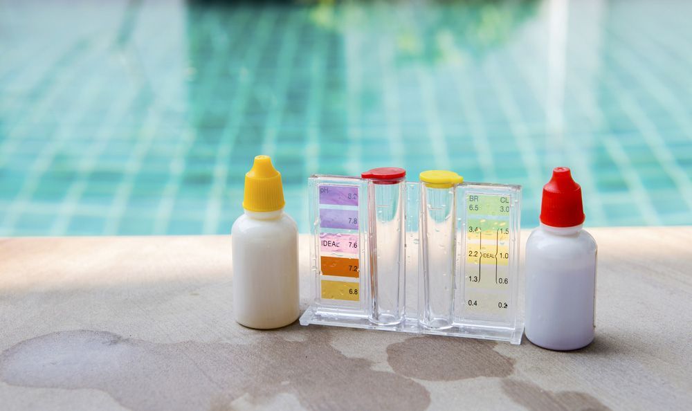 A Bottle of Chemicals is Sitting on the Edge of a Swimming Pool — Taree Pool Supplies in Wingham, NSW