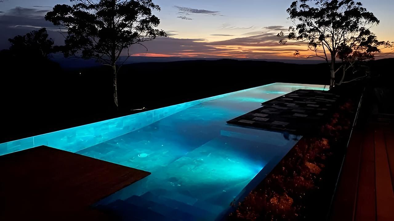 A Swimming Pool With Blue Tiles and Lights Underwater — Taree Pool Supplies in Taree, NSW