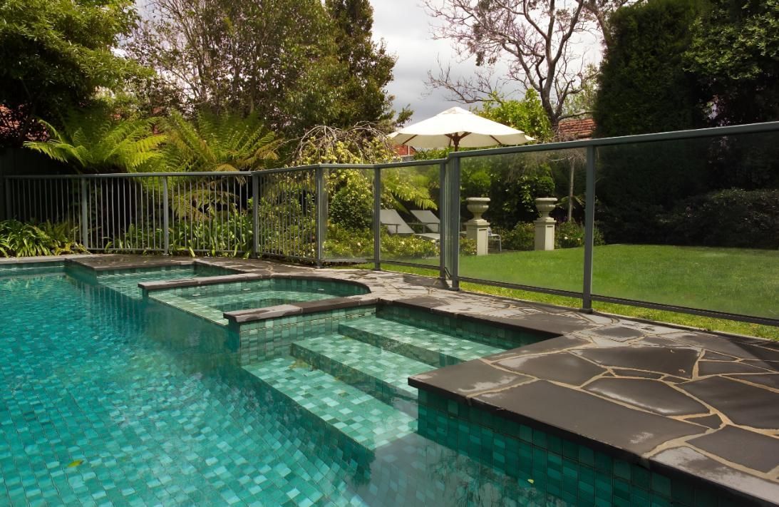 A Large Swimming Pool With Stairs and a Fence in a Backyard — Taree Pool Supplies in Hallidays Point, NSW
