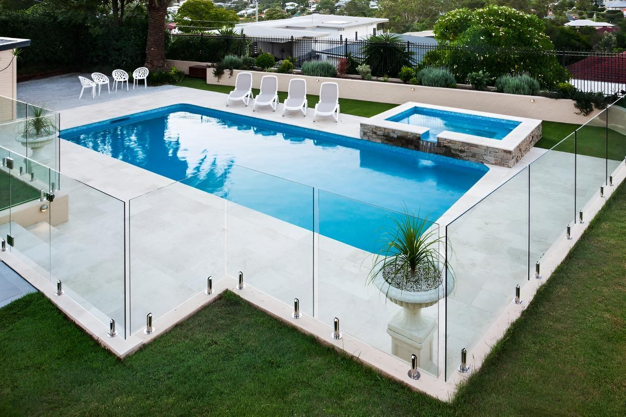 A Large Swimming Pool With a Glass Fence Around It — Taree Pool Supplies in Harrington, NSW