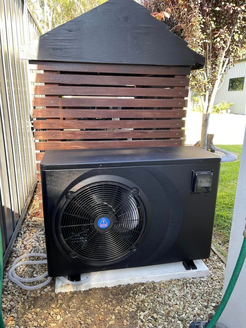 A Black Box is Behind a Metal Fence in a Yard — Taree Pool Supplies in Taree, NSW