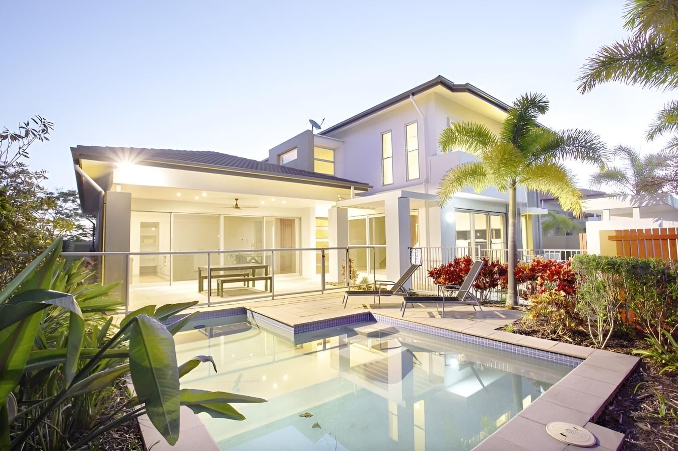 A House With a Swimming Pool in Front of It — Taree Pool Supplies in Harrington, NSW