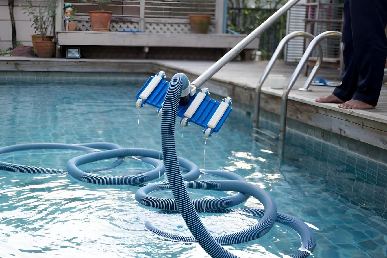 A Person is Cleaning a Swimming Pool With a Hose — Taree Pool Supplies in Old Bar, NSW