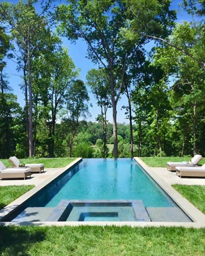 A Large Swimming Pool Surrounded by Chairs and Trees — Taree Pool Supplies in Taree, NSW