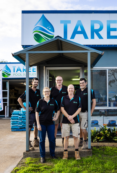 A group of people standing in front of a building that says taree — Taree Pool Supplies in Taree, NSW