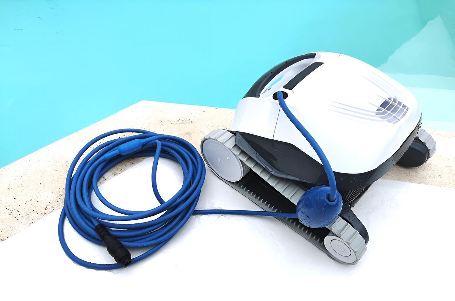 A White Pool Vacuum Cleaner Sits On A Pool Deck