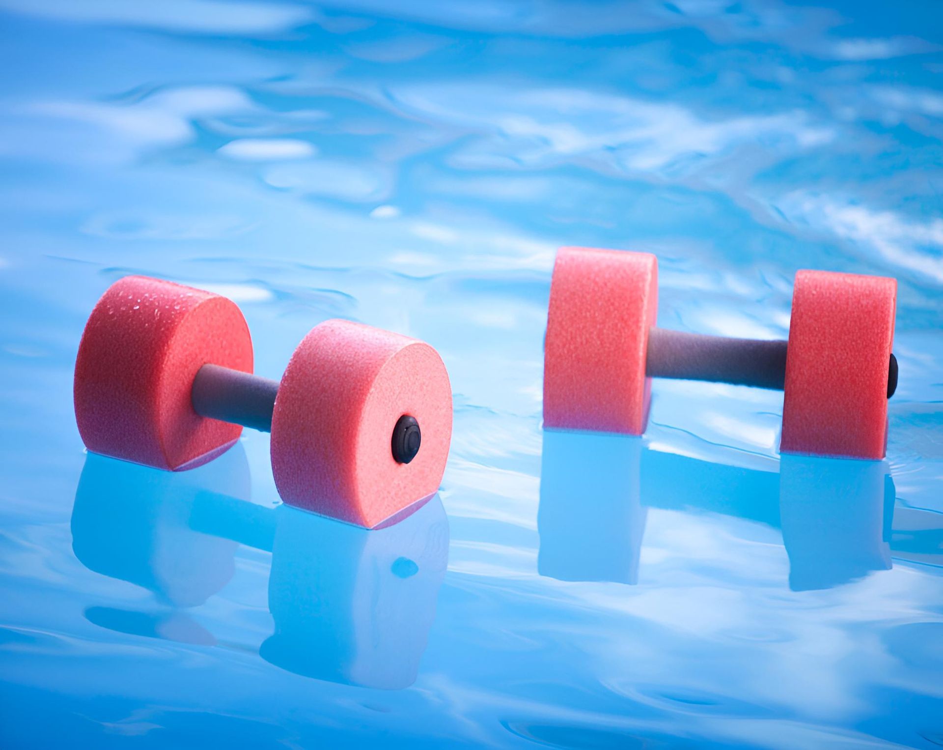 Two Red Foam Dumbbells Are Floating in a Swimming Pool — Taree Pool Supplies in Forster, NSW