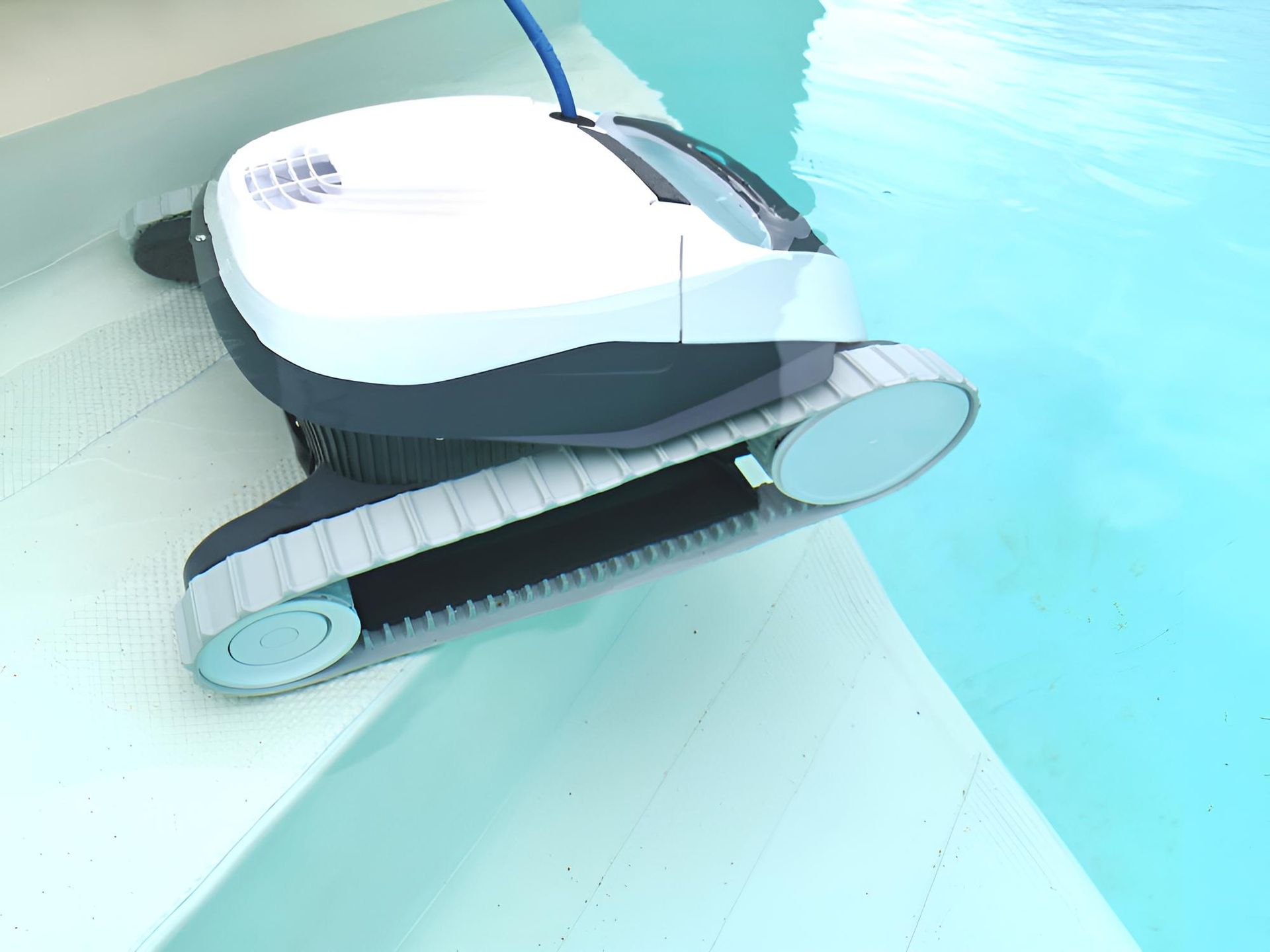 A Robotic Vacuum Cleaner is Sitting on the Edge of a Swimming Pool — Taree Pool Supplies in Forster, NSW