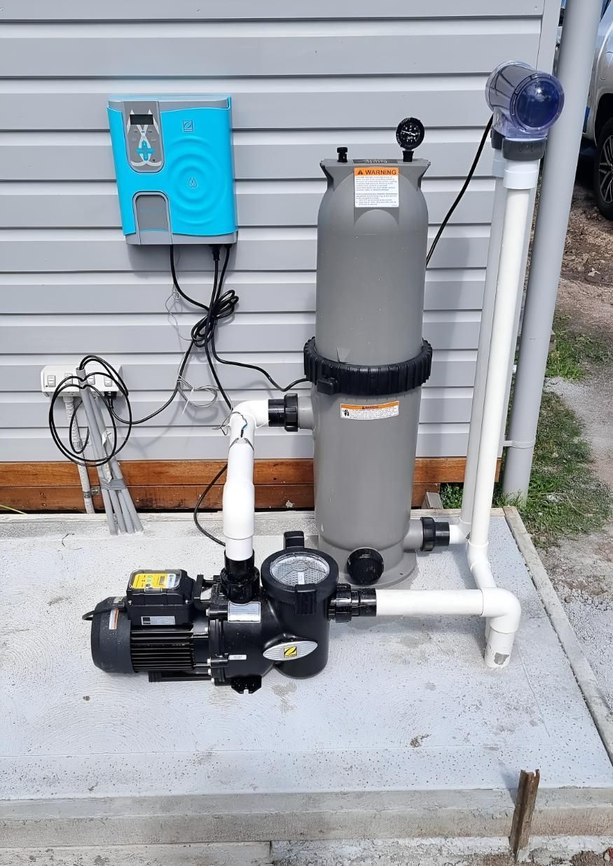 A Swimming Pool Filter and Pump Are Sitting on the Side of a Building — Taree Pool Supplies in Forster, NSW