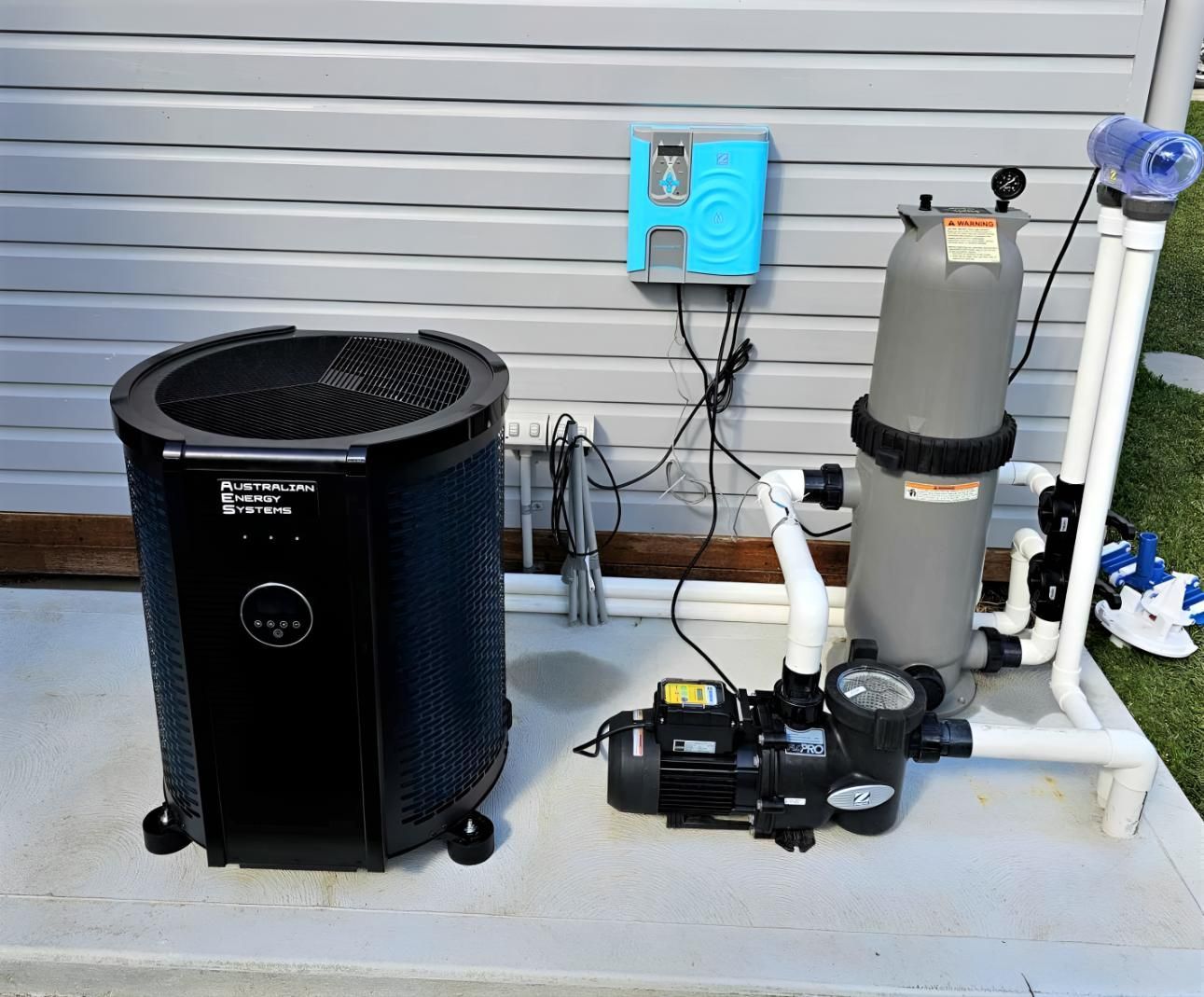 A Pool Pump and Heater Are Sitting on the Side of a House — Taree Pool Supplies in Forster, NSW