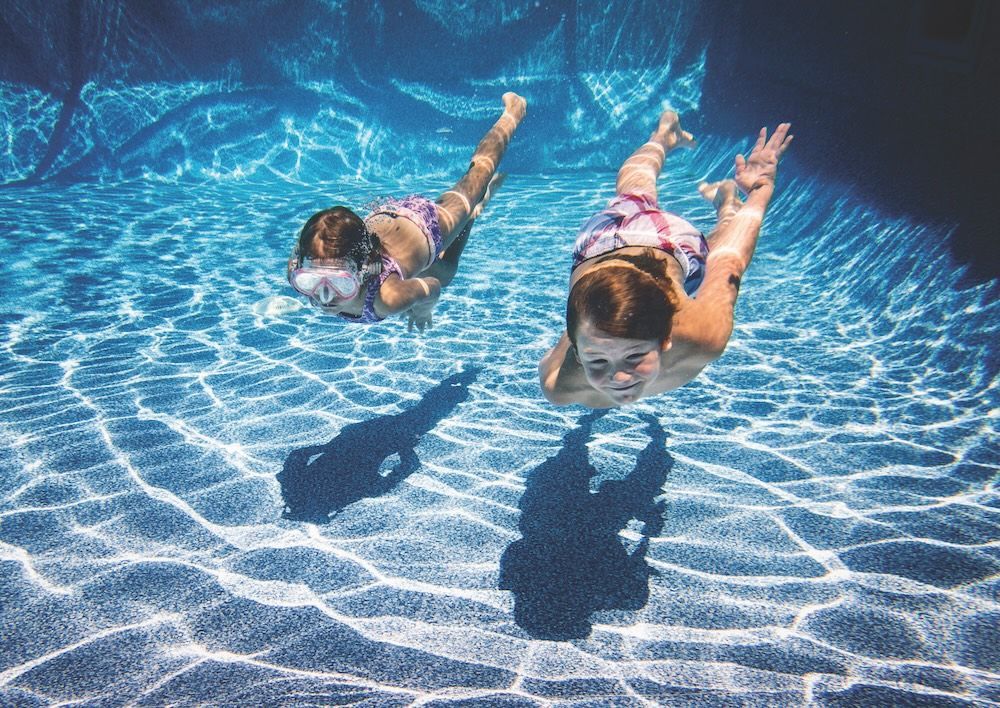 Two Young Girls Are Swimming Underwater in a Swimming Pool — Taree Pool Supplies in Taree, NSW
