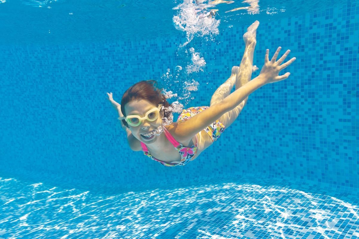 A Little Girl is Swimming Underwater in a Swimming Pool — Taree Pool Supplies in Taree, NSW
