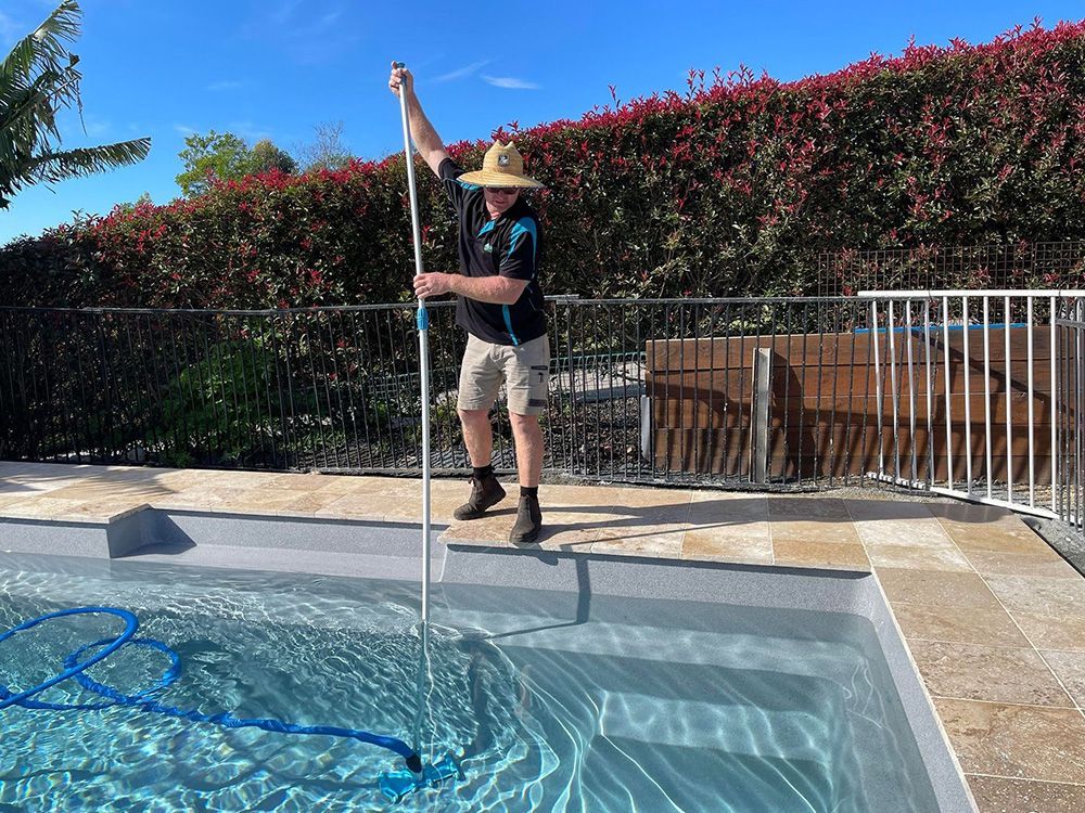 Man Cleaning A Pool With A Long-Handled Vacuum — Taree Pool Supplies in Forster, NSW