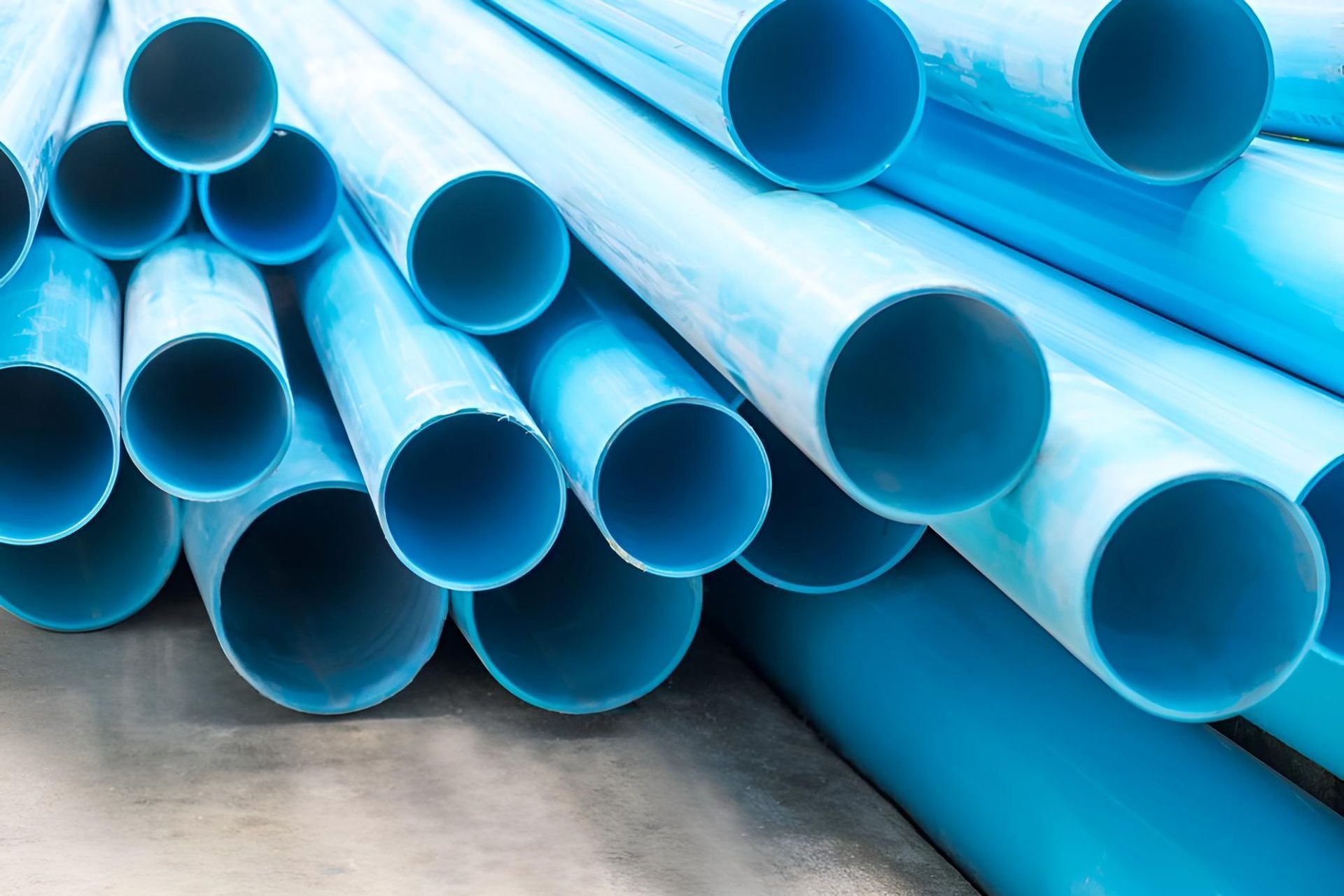 A Pile of Blue Plastic Pipes Stacked on Top of Each Other on the Ground — Taree Pool Supplies in Forster, NSW
