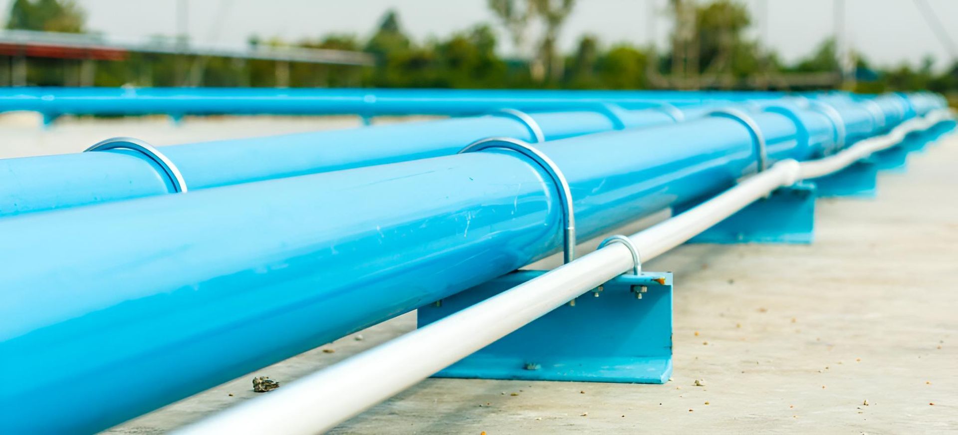 A Row of Blue Pipes Sitting on Top of a Concrete Surface — Taree Pool Supplies in Forster, NSW