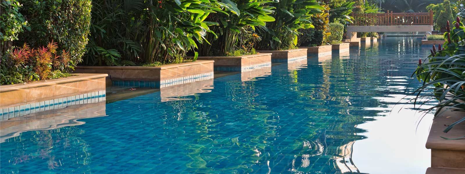 A Large Swimming Pool Surrounded by Trees and Bushes — Taree Pool Supplies in Wingham, NSW