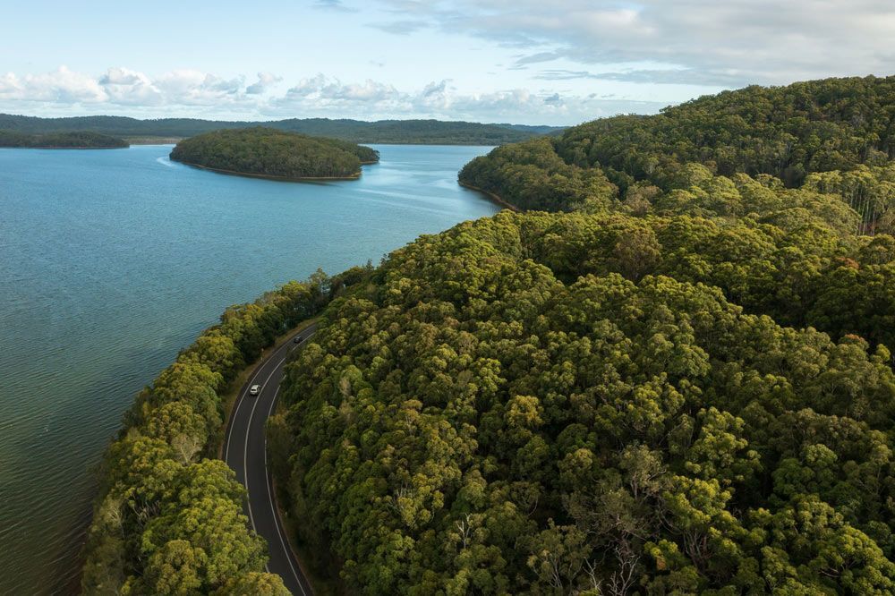 An Aerial View of a Road Going Through a Lake Surrounded by Trees — Taree Pool Supplies in Smiths Lake, NSW