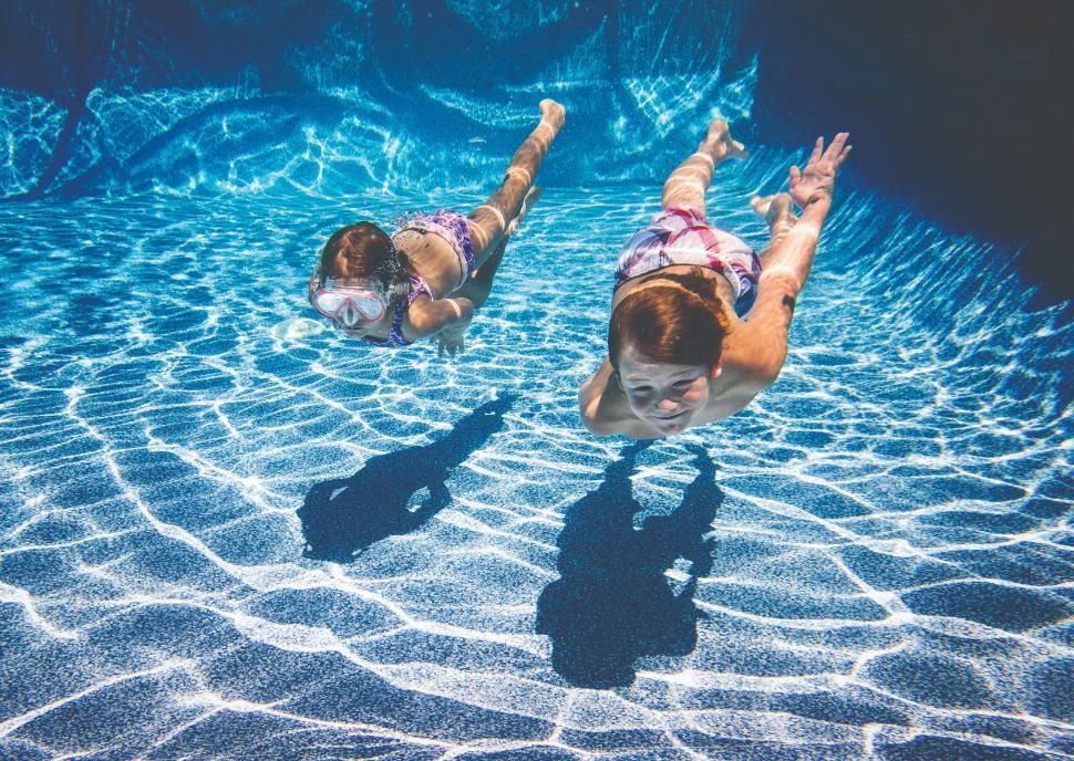 Two Young Girls Are Swimming Underwater in a Swimming Pool — Taree Pool Supplies in Taree, NSW
