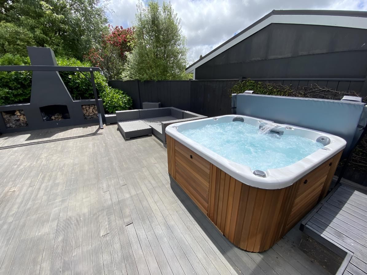 A Hot Tub is Sitting on Top of a Concrete Deck — Taree Pool Supplies in Forster, NSW