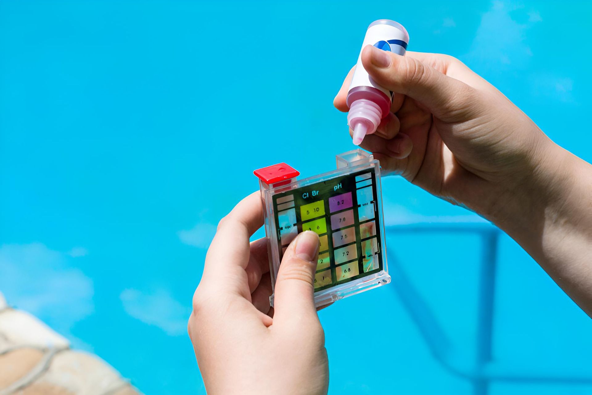 A Person is Holding a Test Kit in Front of a Swimming Pool — Taree Pool Supplies in Forster, NSW