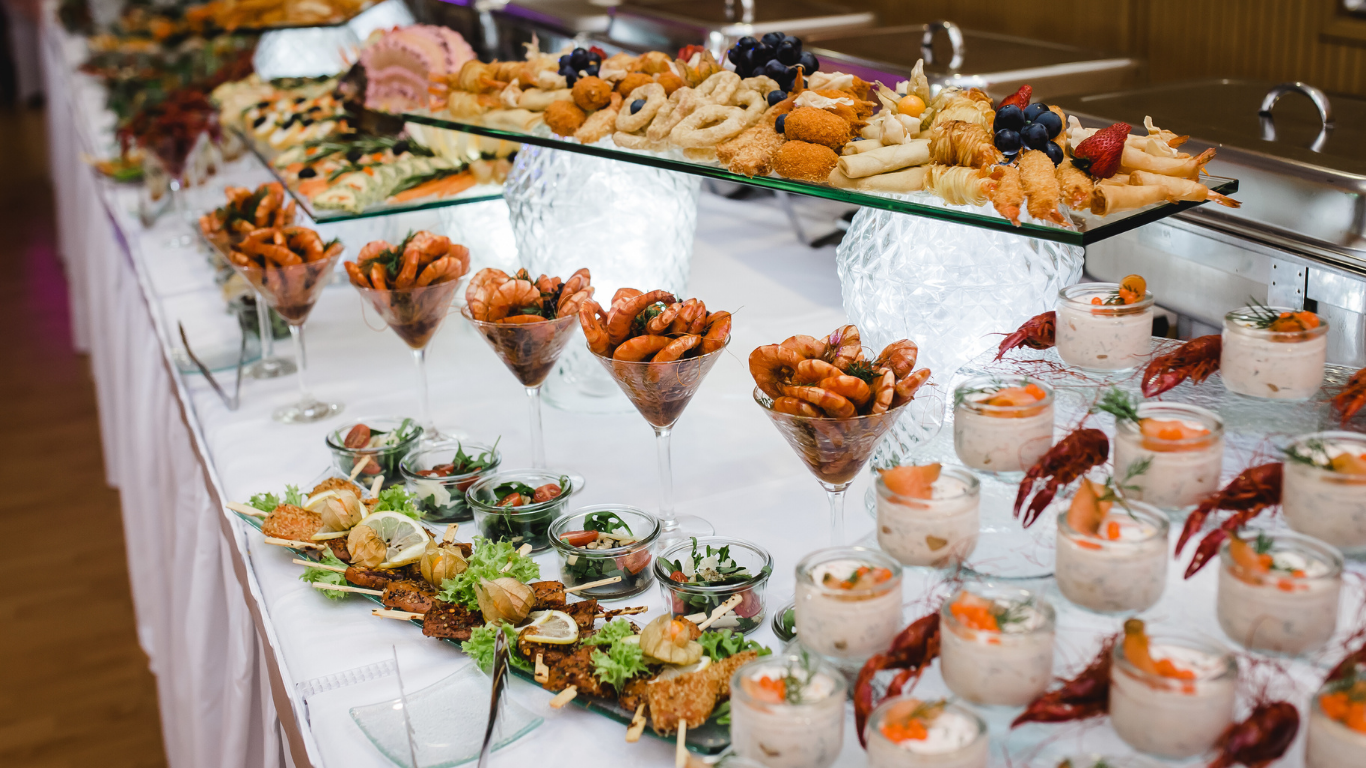 Woman laughing, eyes closed, mouth open. Wearing green shirt, brown hair against white backdrop.