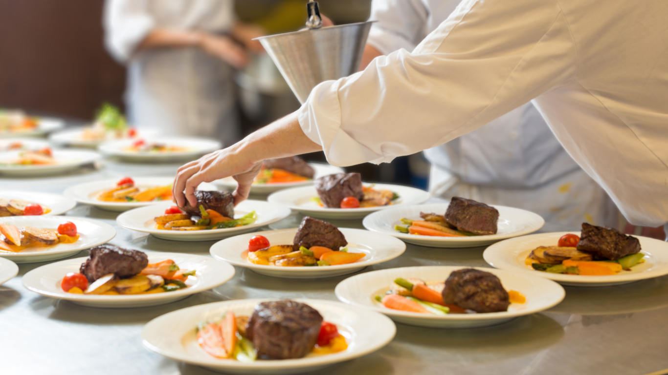 Woman in green shirt laughing with eyes closed.