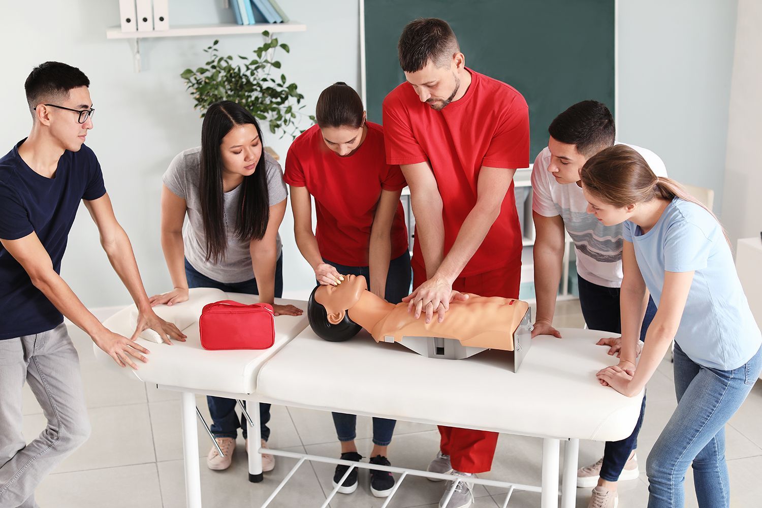 An instructor is giving a CPR course. An instructor is giving a CPR course.