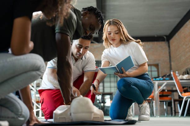 A group of people are kneeling down and looking at a model of a heart.