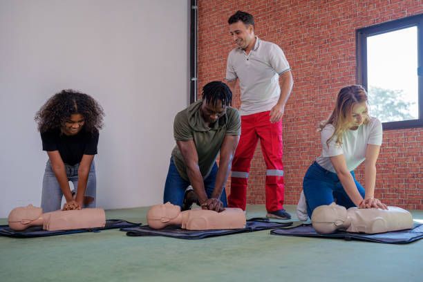 A group of people are practicing first aid on a mannequin.