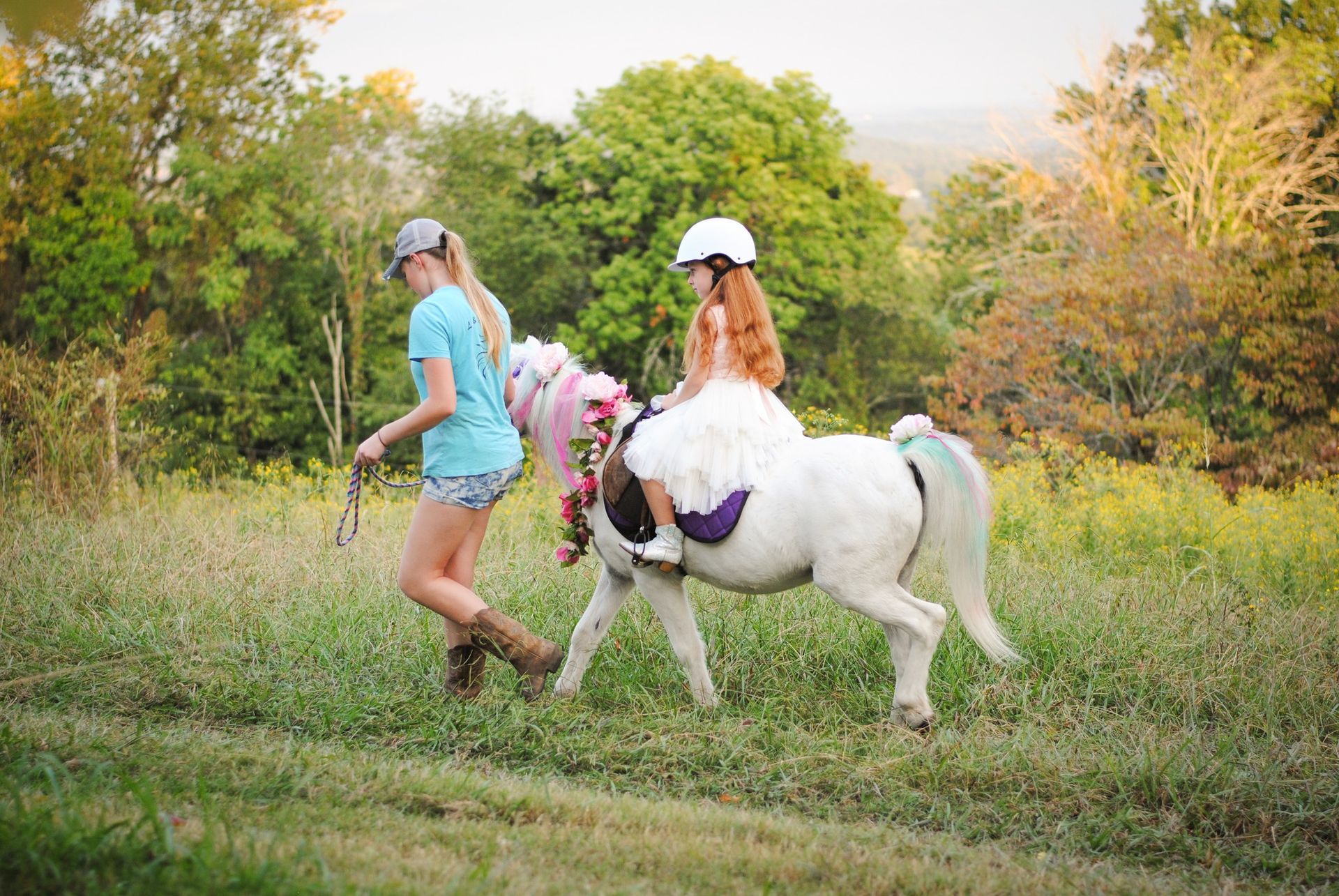 A little girl is riding a pony in a field.