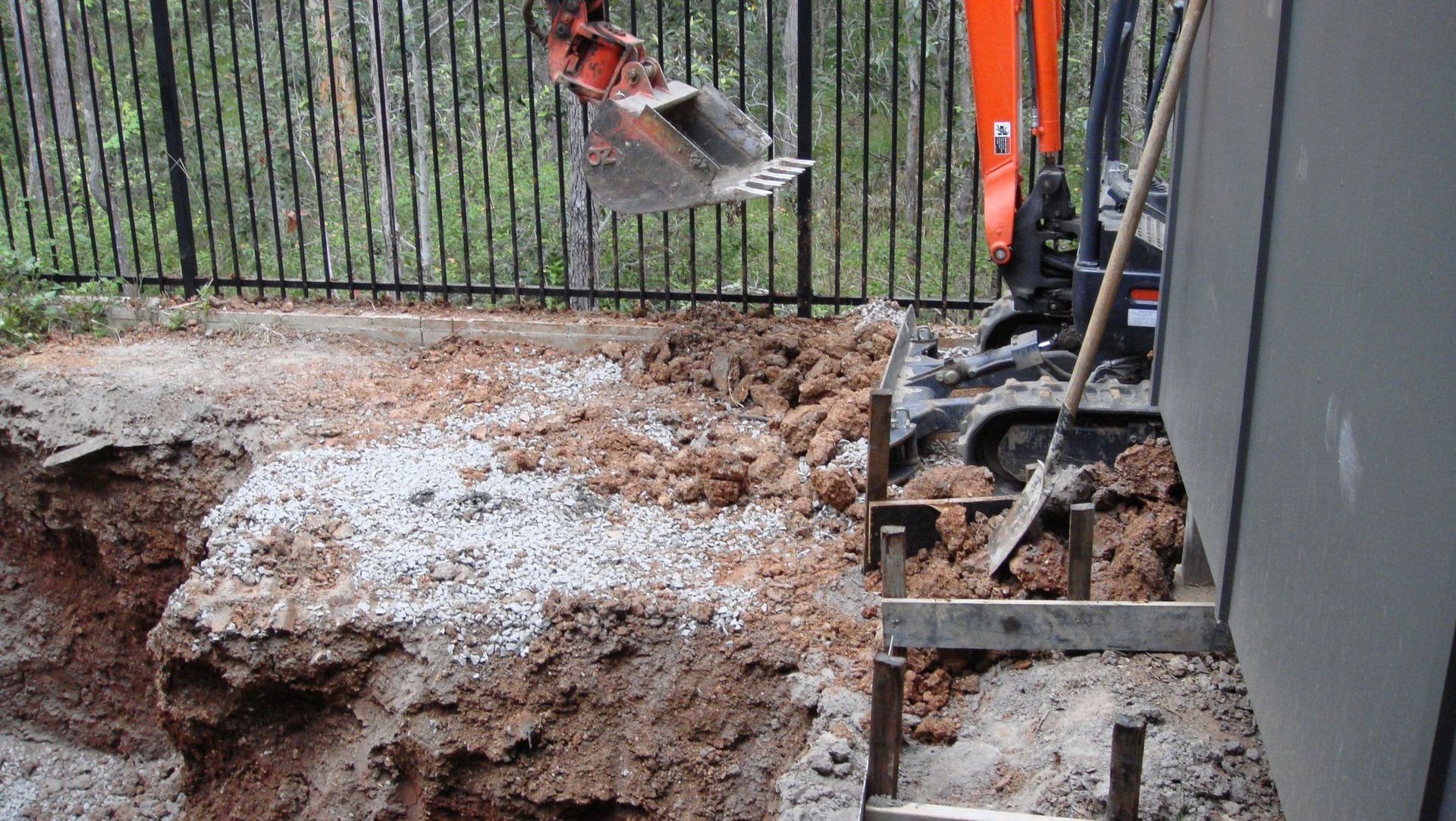 An excavator digging near a fence and steps. Earth tones dominate the scene.