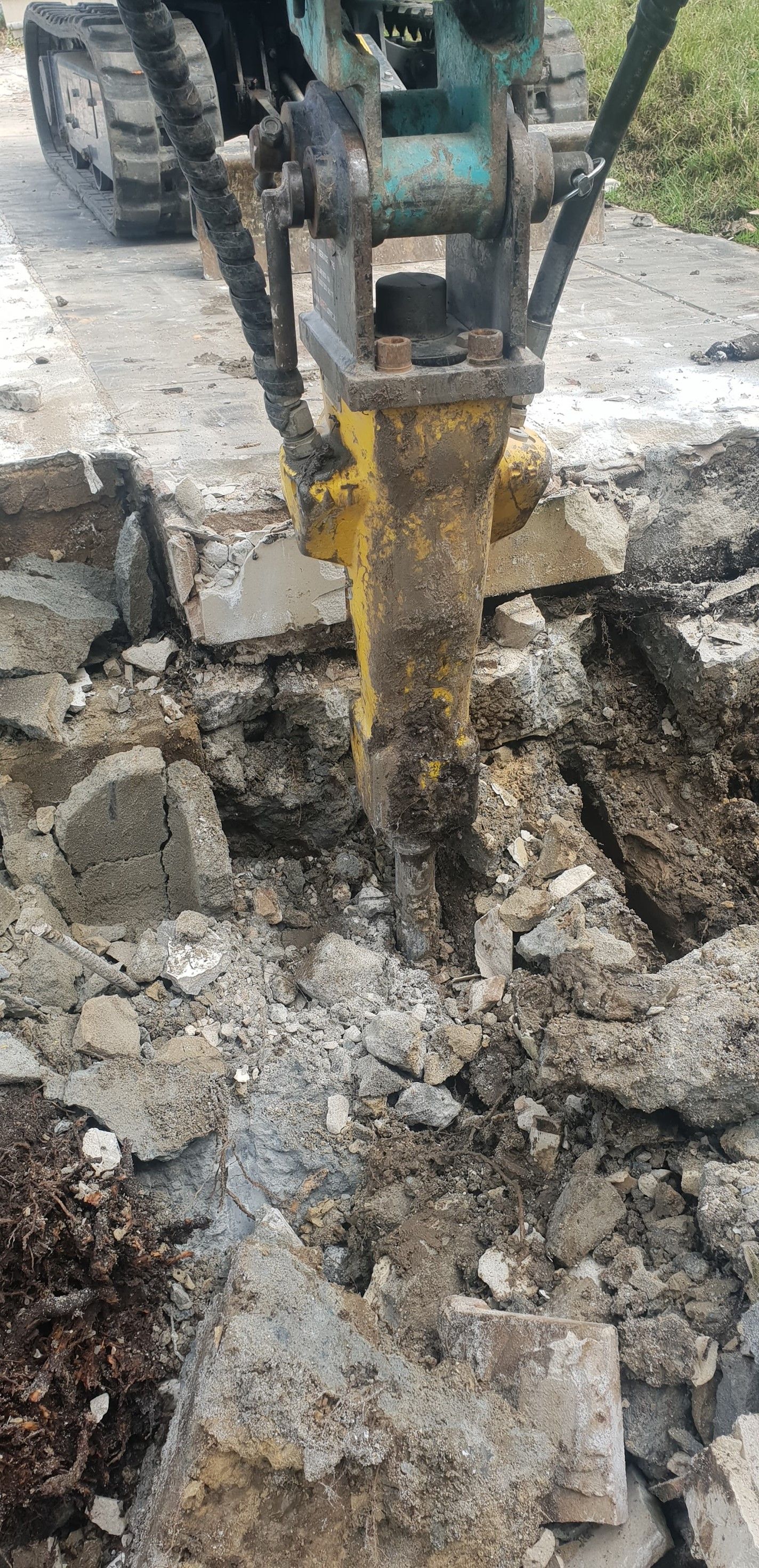 A jackhammer breaking up a concrete surface.