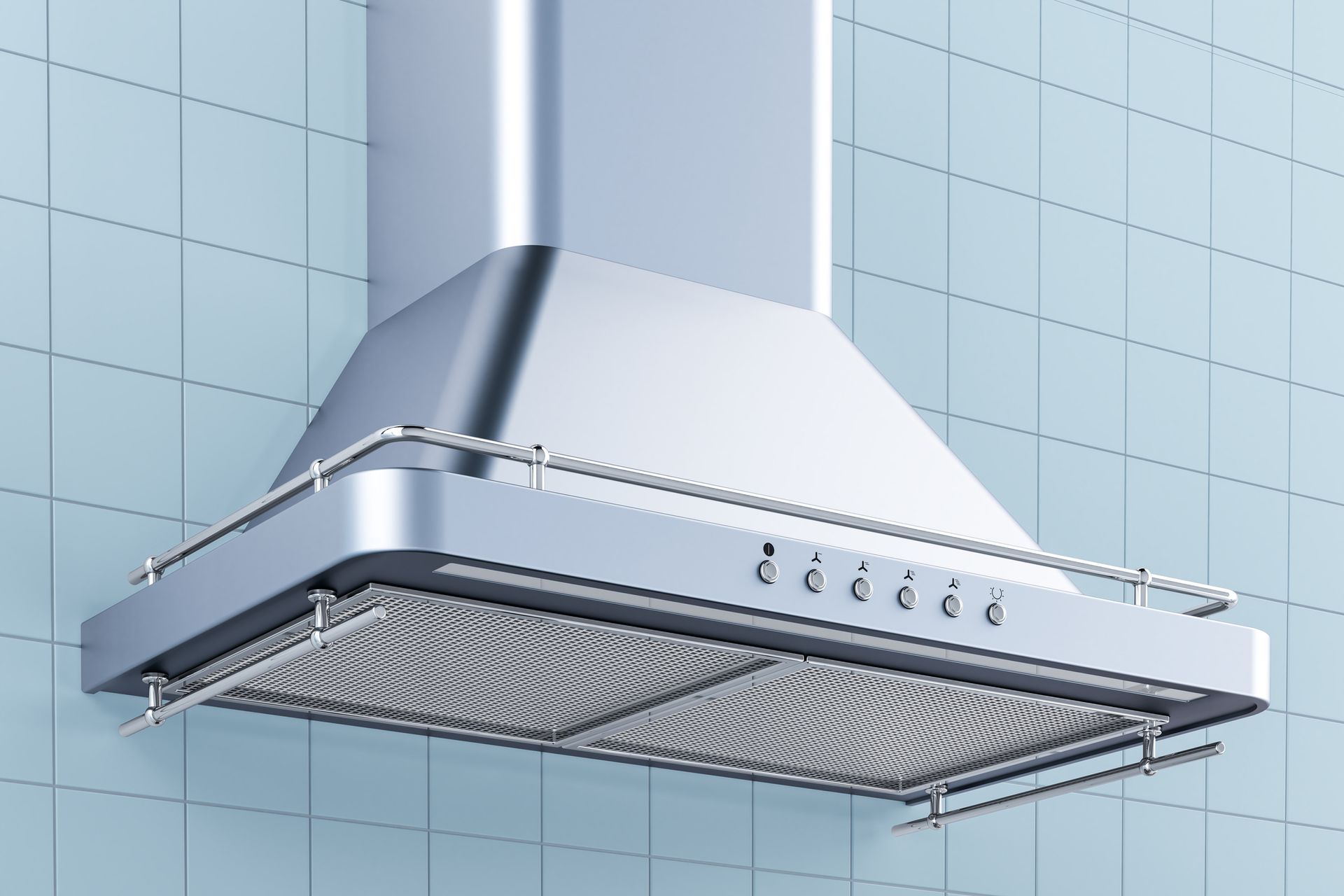 Stainless steel range hood over a stove, against a light blue tiled wall.