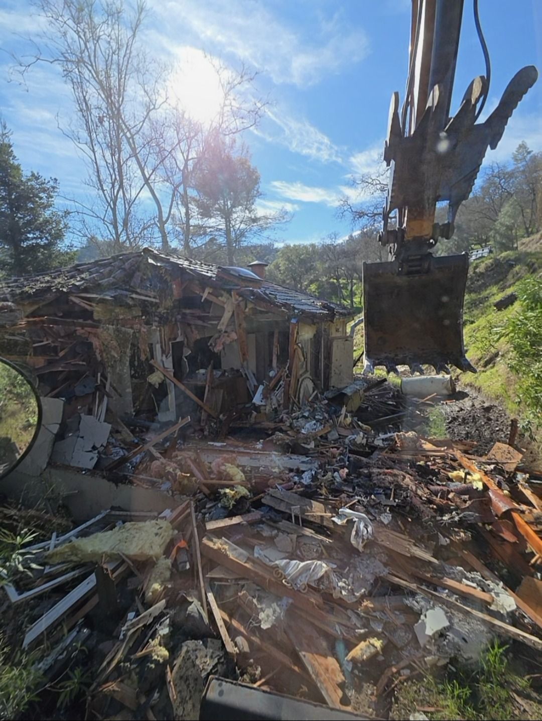 Yellow excavator digging dirt in an outdoor setting, likely a construction site.