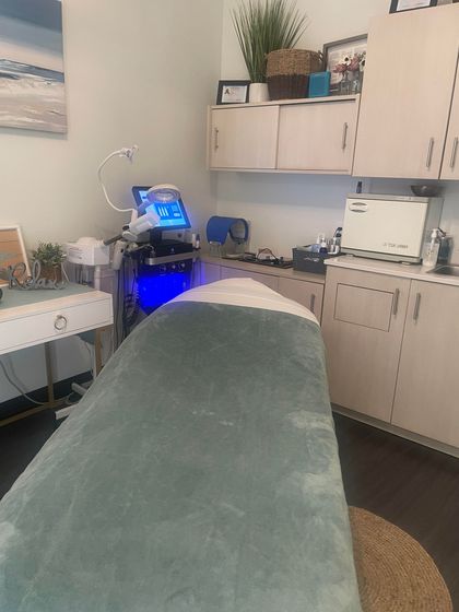 A massage table in a room with a blue blanket on it.