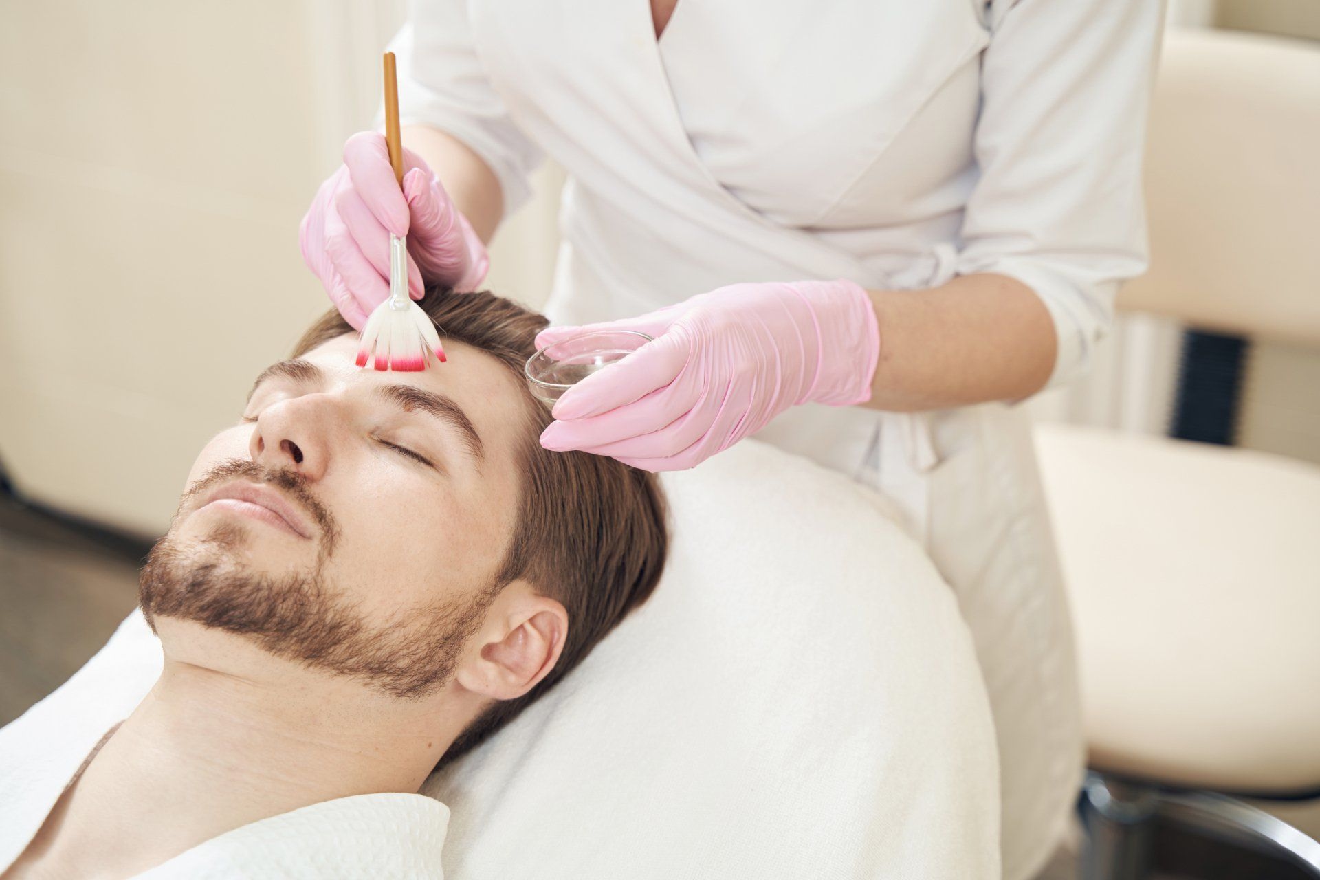 A man is getting a facial treatment at a spa.