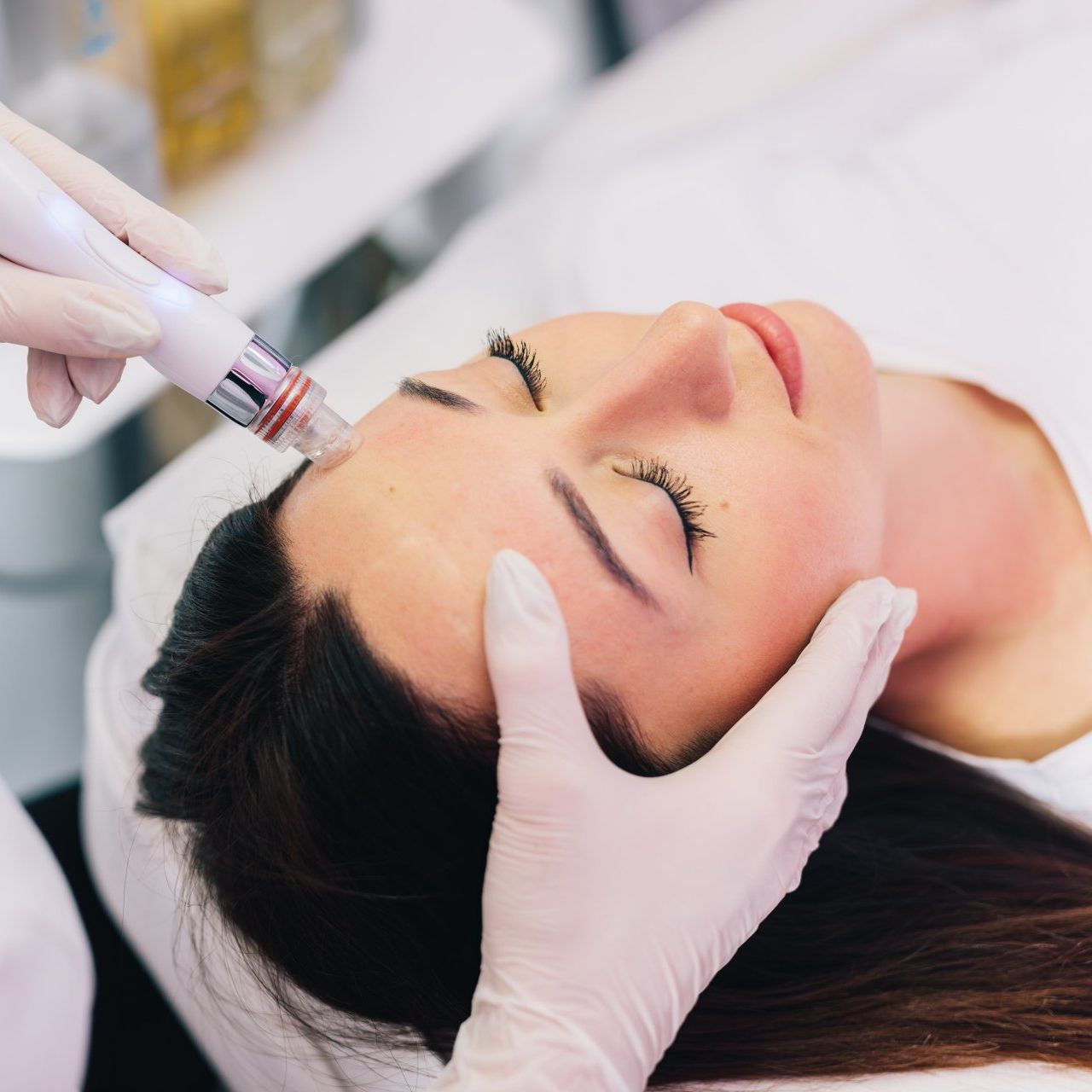 A woman is getting a facial treatment with a syringe