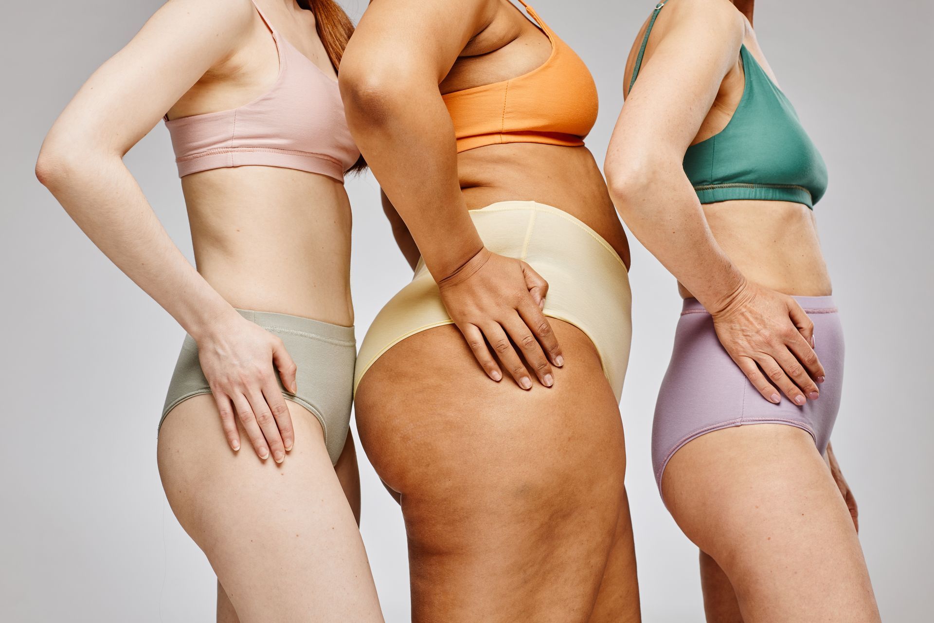 Three women in underwear are standing next to each other.