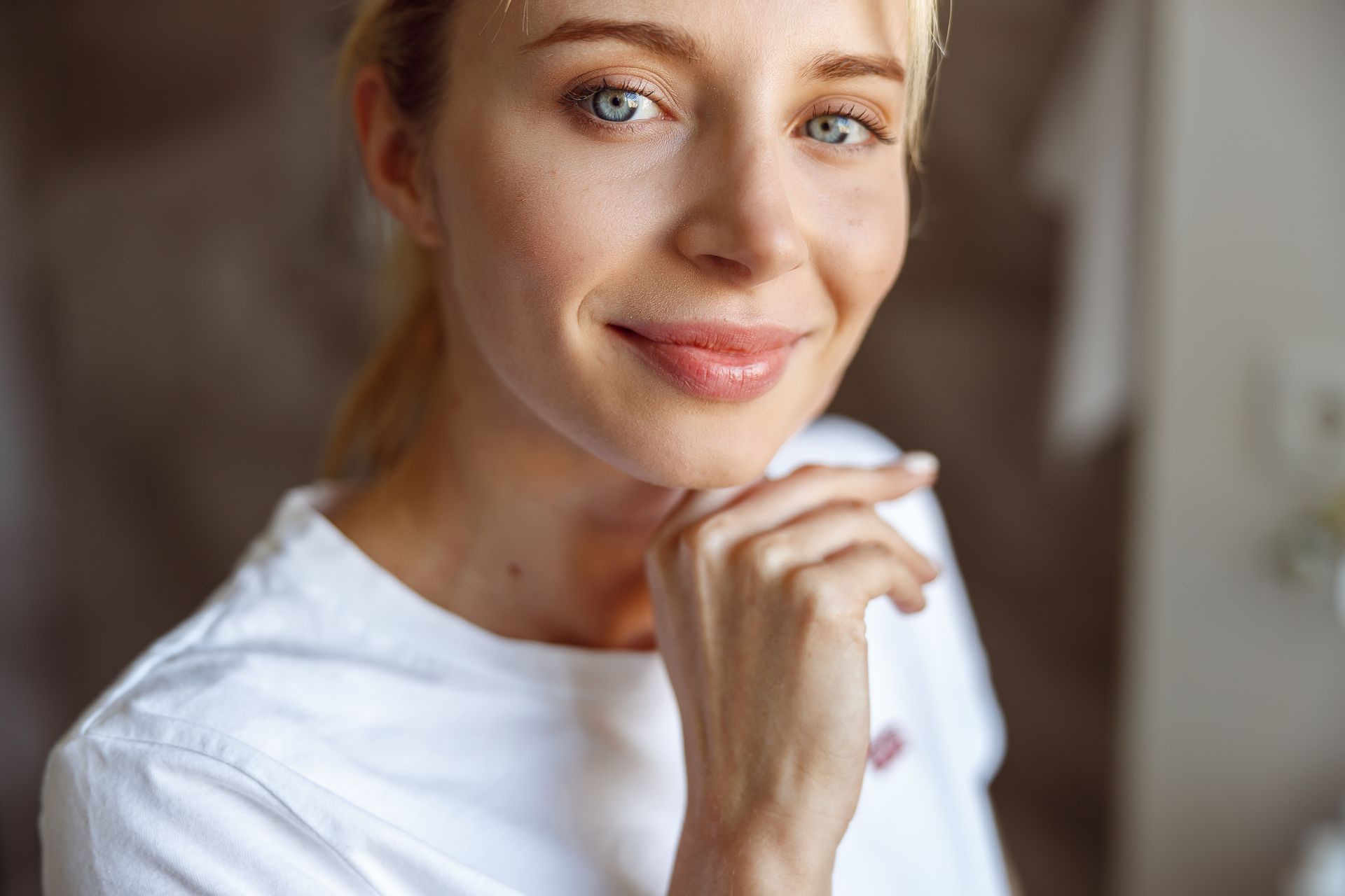 A close up of a woman 's face with her hand on her chin.