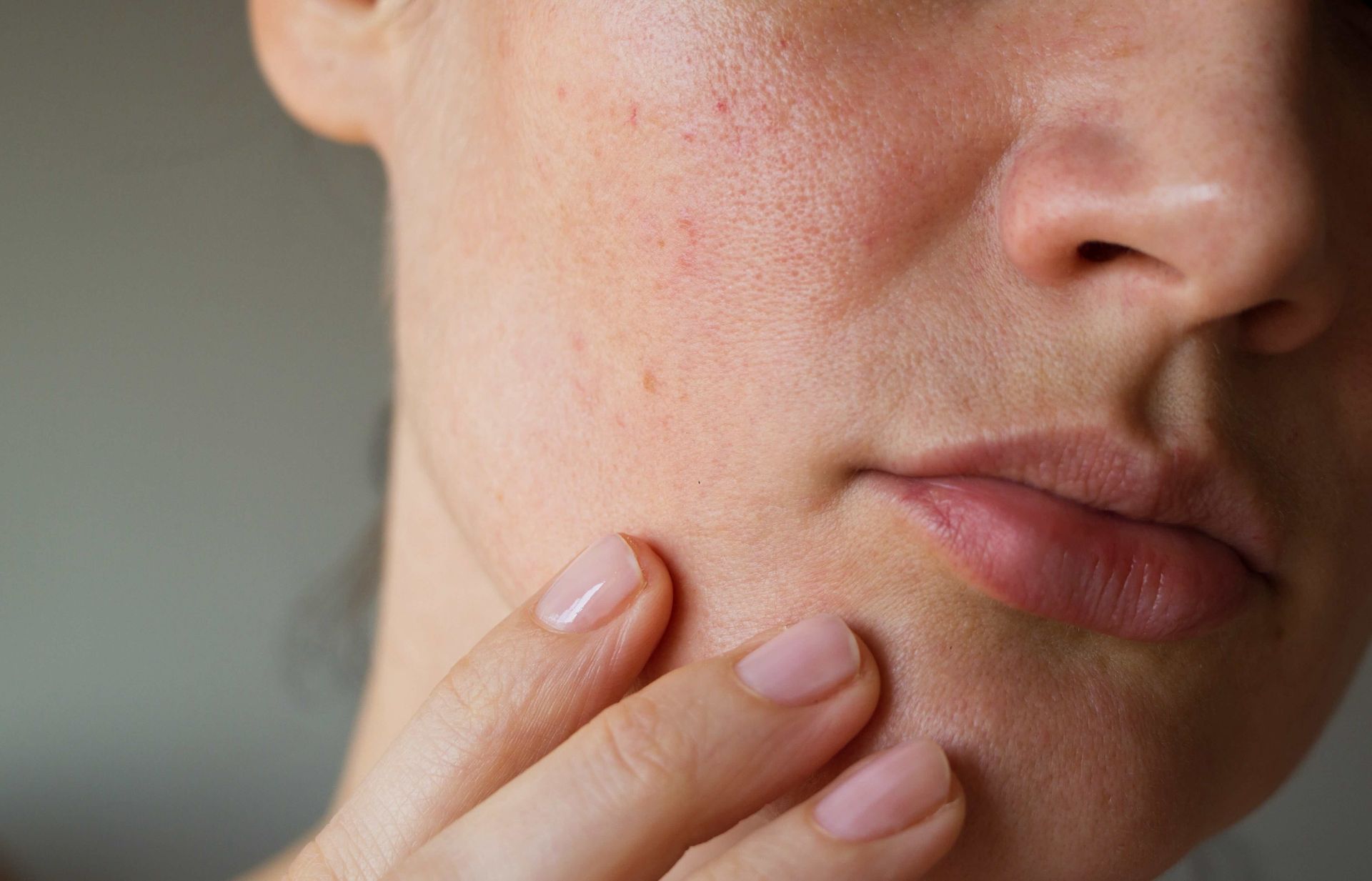 A close up of a woman 's face with her hand on it.