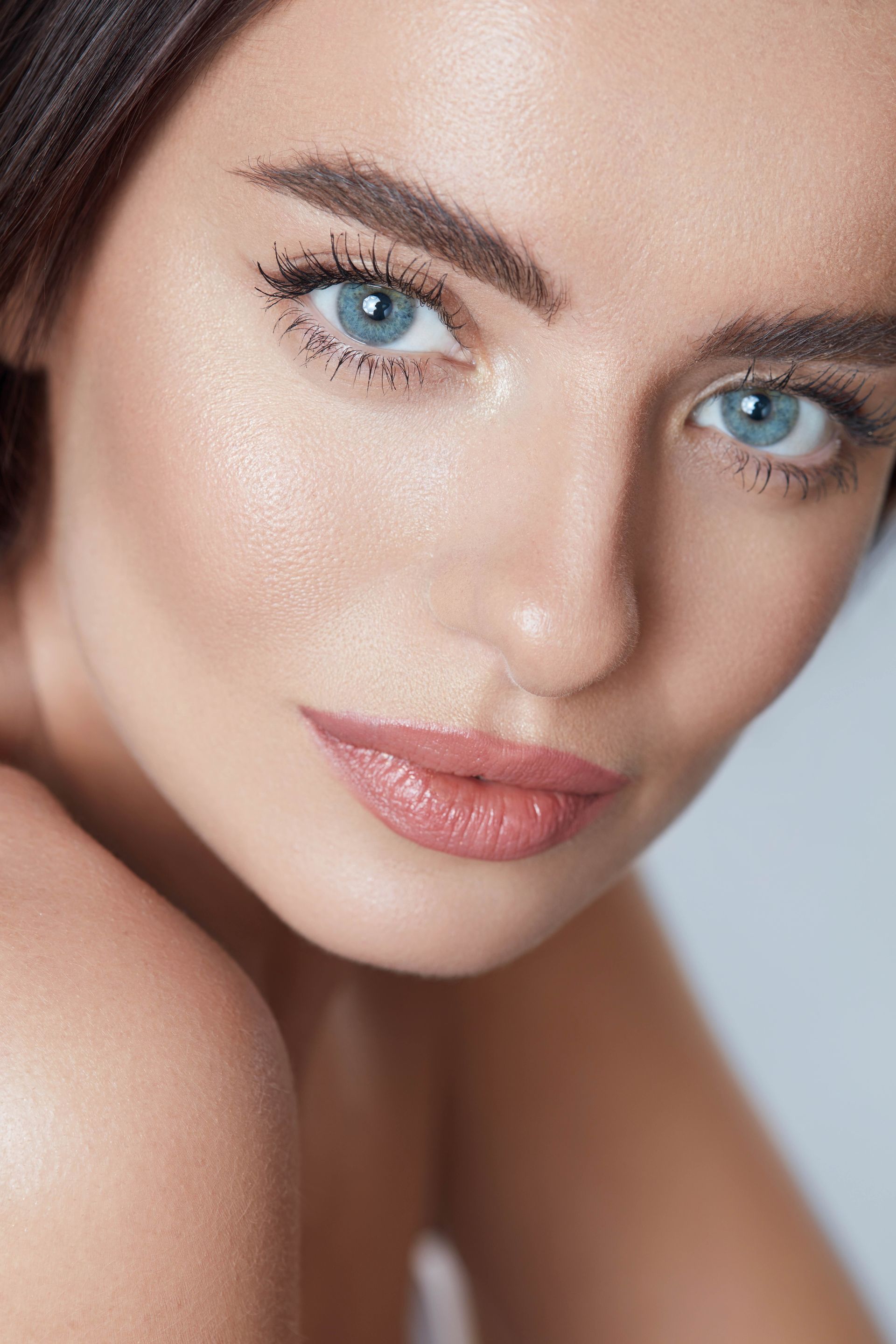 A close up of a woman 's face with blue eyes and mascara.