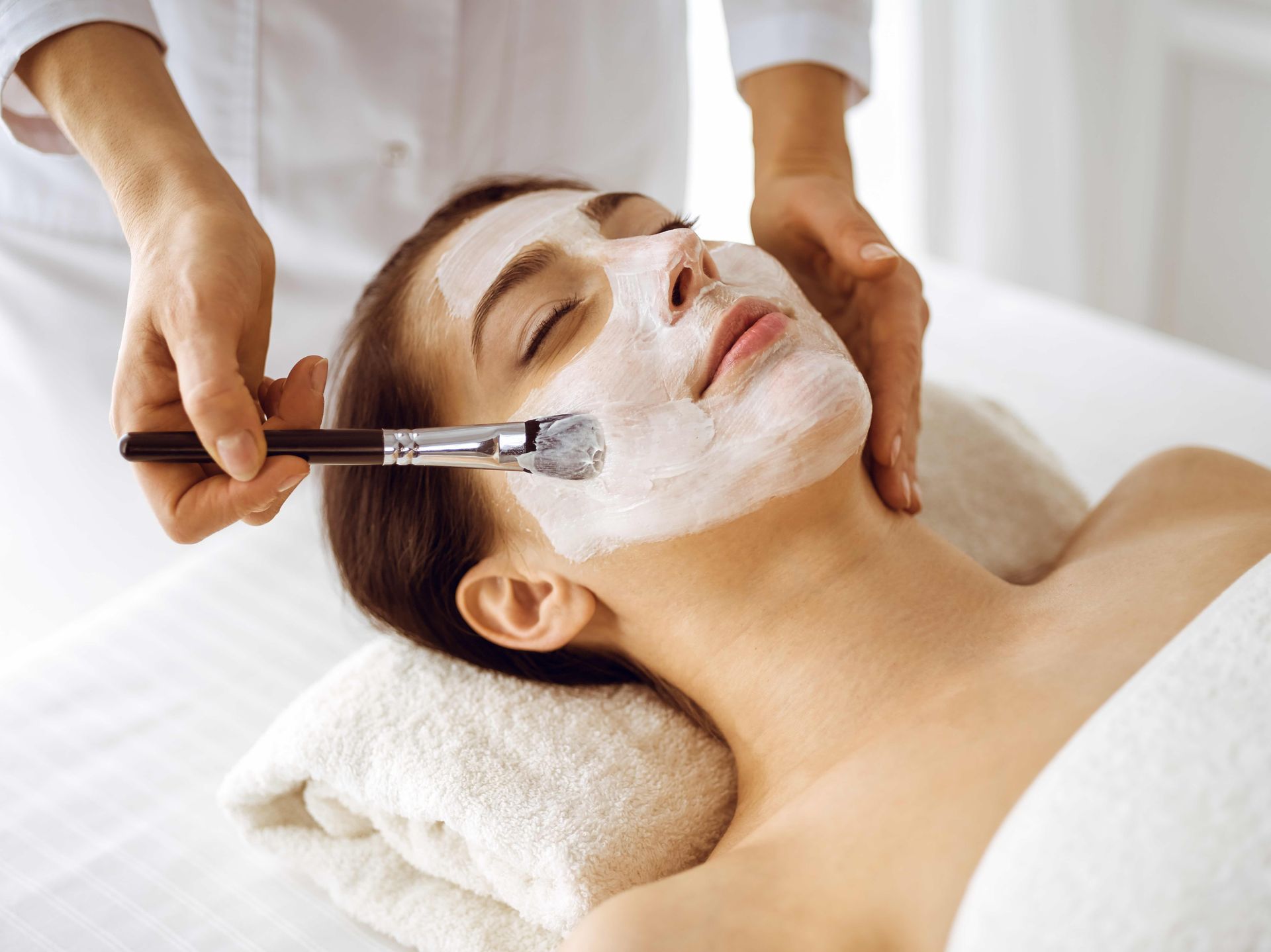 A woman is getting a facial treatment at a spa.