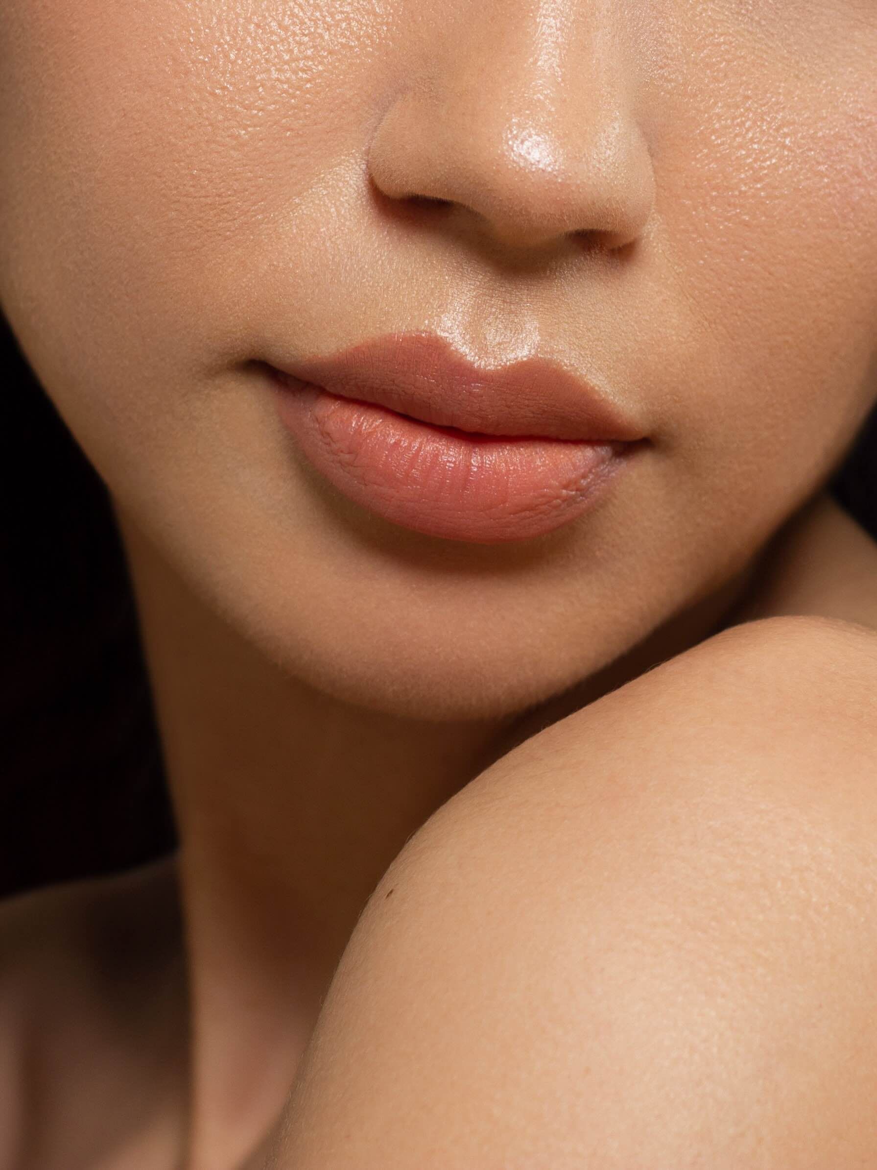 A close up of a woman 's face with a black background.