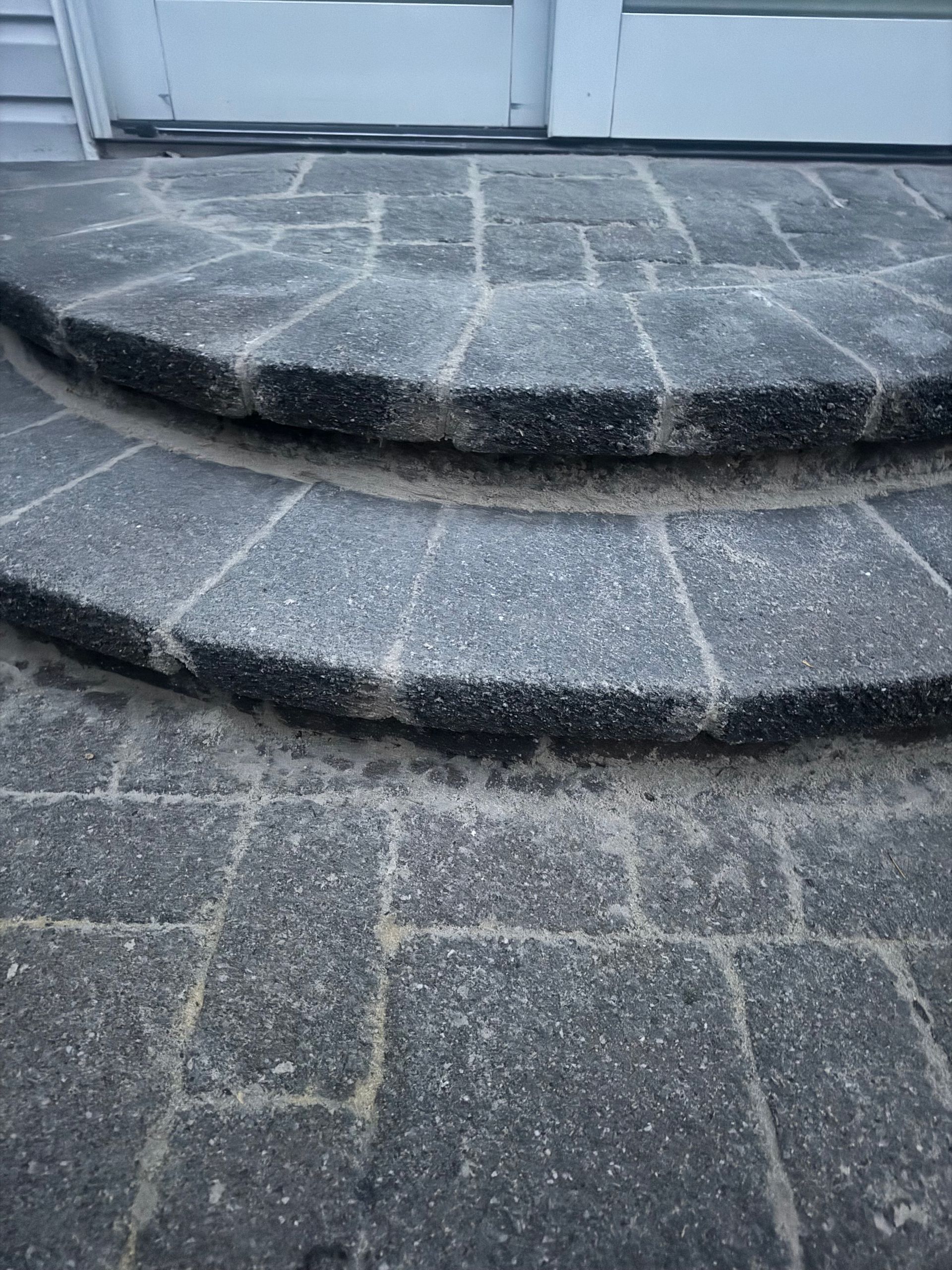 Two stone steps leading to a doorway. The steps are semi-circular and grey.